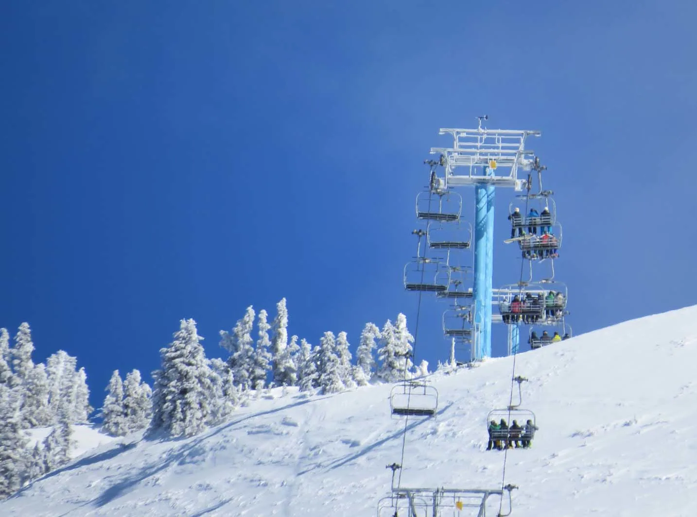 Close up of skiers and snowboards riding a chairlift at Mount Washington Ski Resort on Vancouver Island