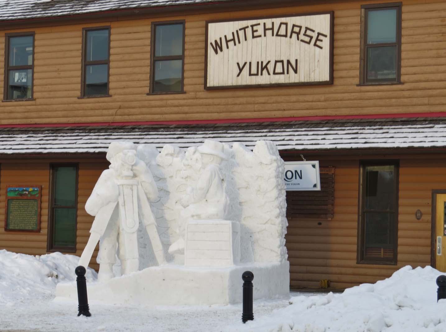 Carved ice sculpture in front of wooden building