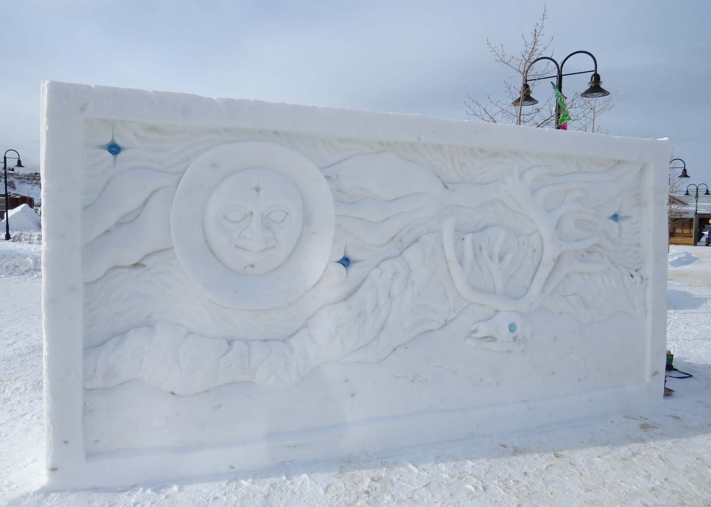 Large ice sculpture of the moon with a face looking at an elk skull in Yukon