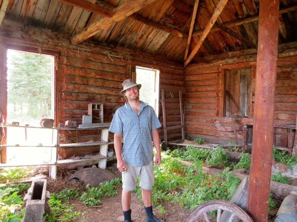 JR standing in a wooden building with plants growing in underneath