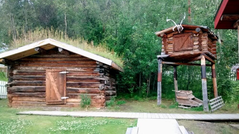 Small wooden cabin with elevated food cache to the right