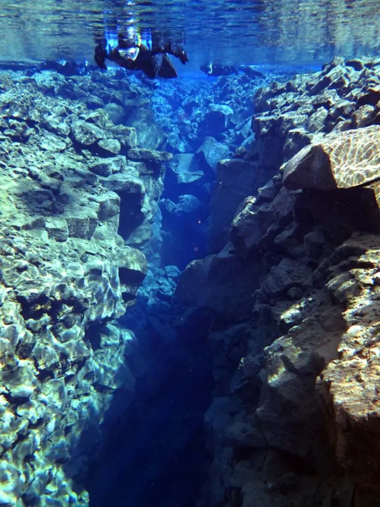 snorkeler and cliff colors iceland fissure