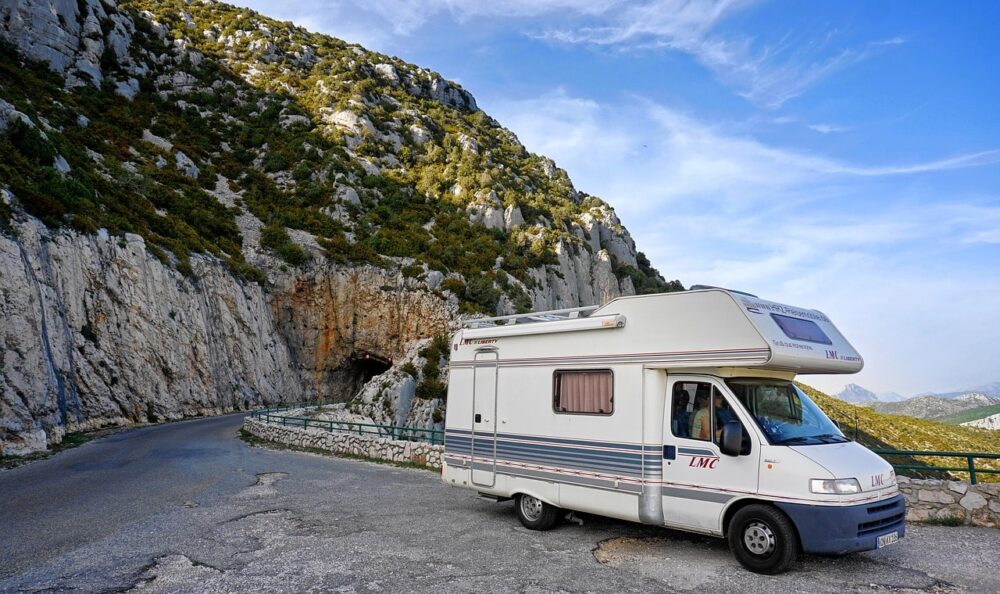 Campervan on the road in France, bordered by mountains