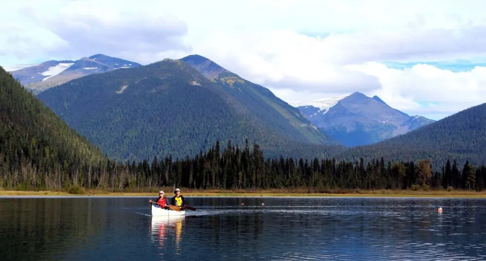 JR and Gemma paddling on Bowron Lakes Canoe Circuit, one of the best canoe trips in Canada