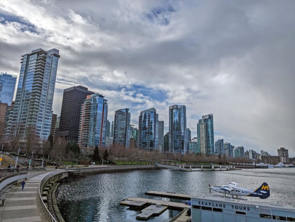 Coal Harbour area of Vancouver with paved coastal path next to ocean with skyscrapers in background