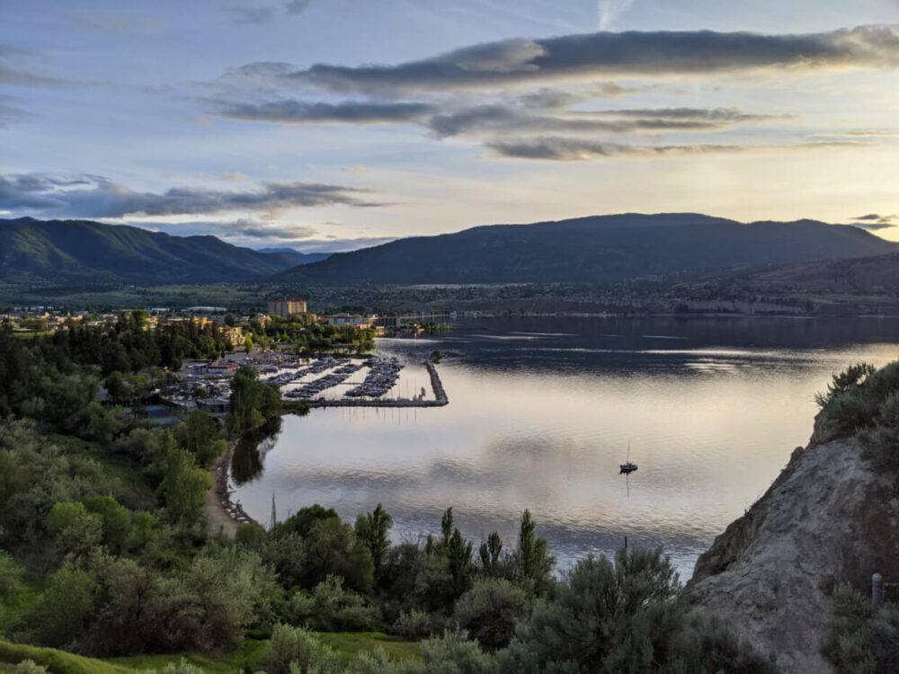 Elevated view looking down on the city of Penticton wth calm lake and marina