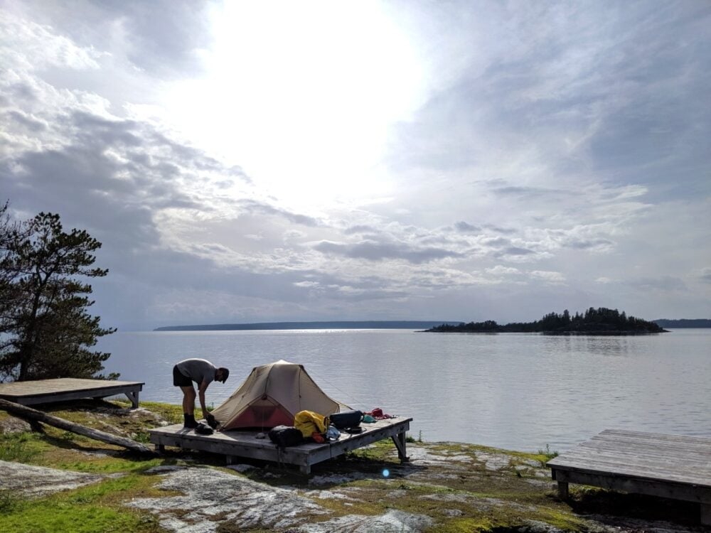 JR setting up a tent on a wooden tent platform in Desolation Sound