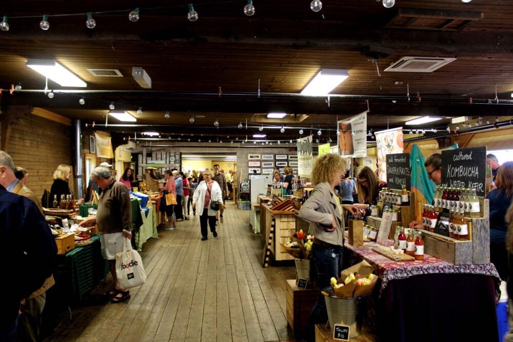 Interior view of Wolfville Farmer's Market with stalls on either side of the walking area