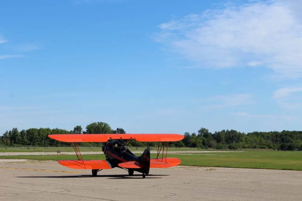 red and black bi-plane on airstrip