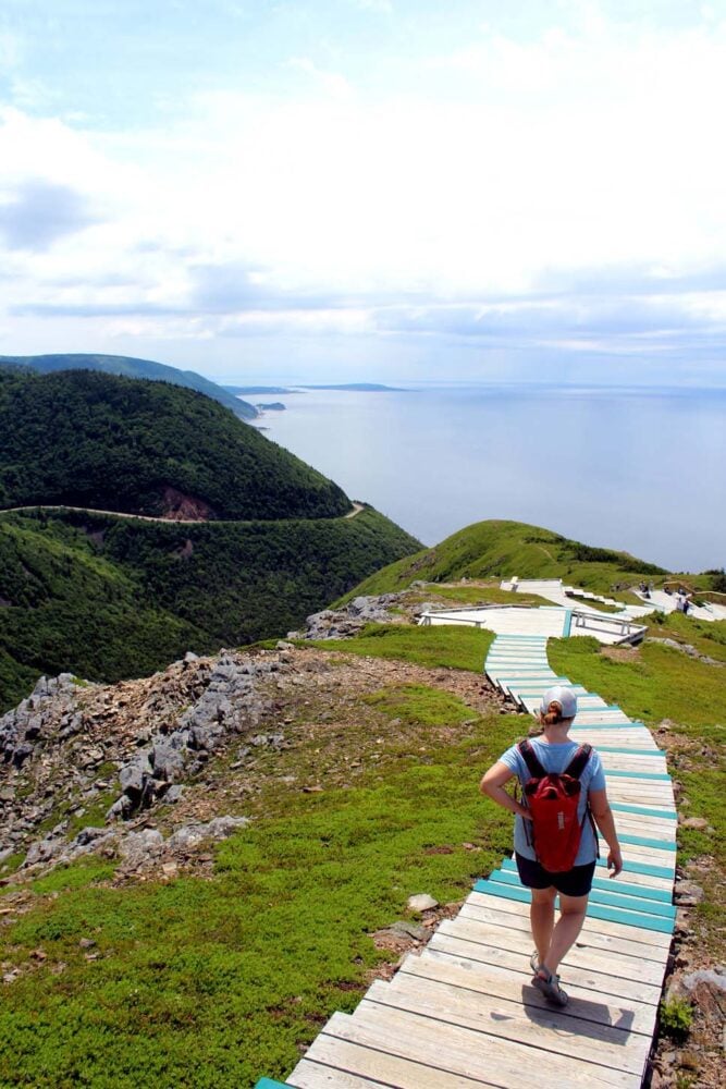 Gemma walking down the Skyline steps, ocean and headland in background