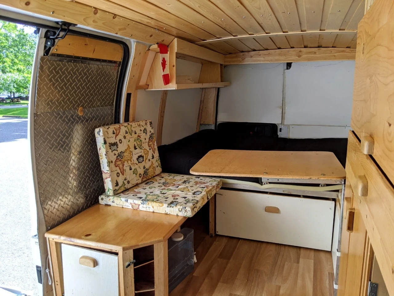 Inside view of GMC Savana conversion van with seating and table in middle