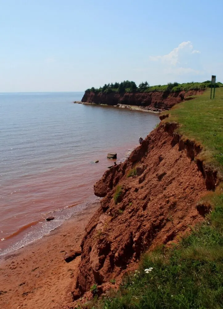 Red cliffs with narrow red sand beach at bottom
