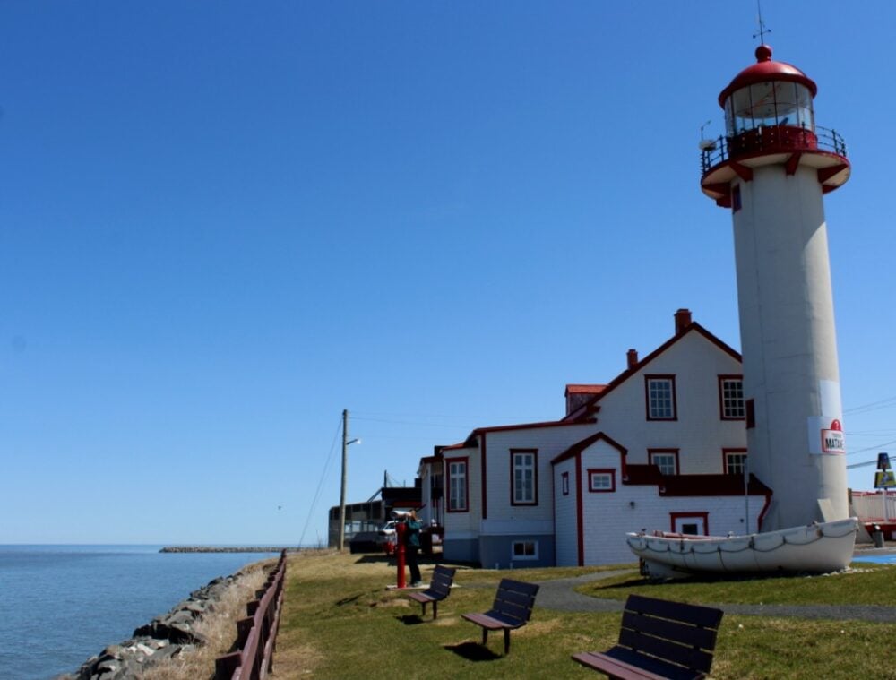 White and red lighthouse building in Matane with coastline