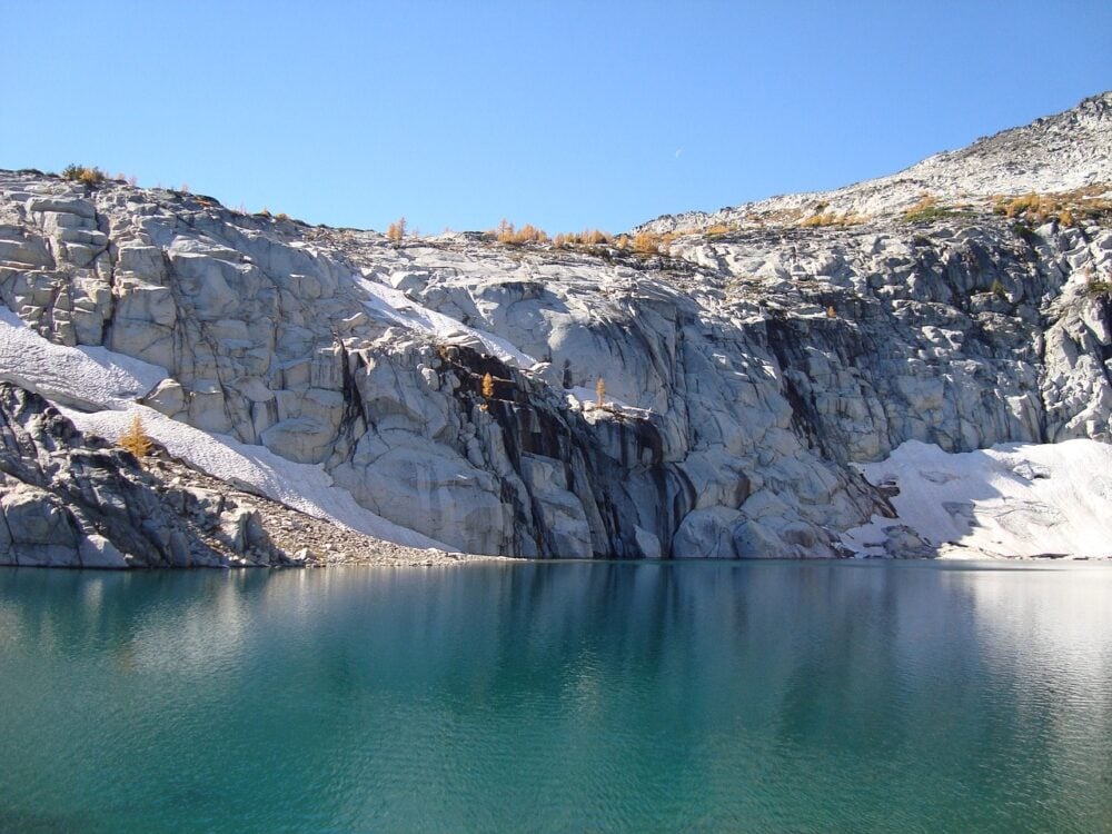 Bright glacial lake surrounded by cliffs and larch trees, in the Enchantments