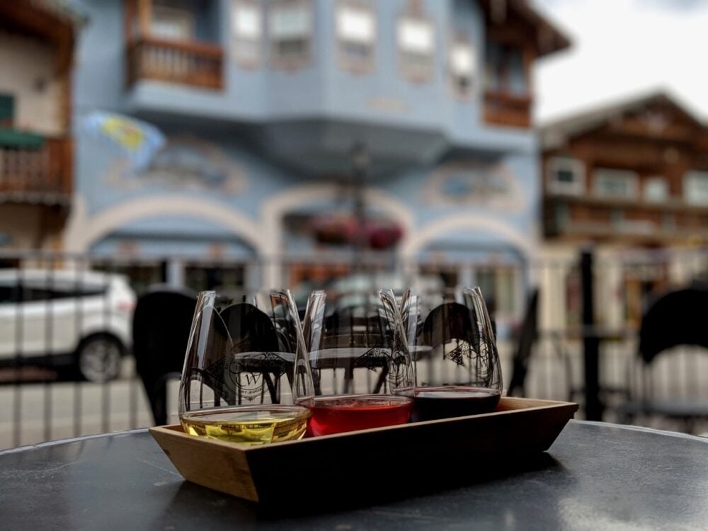Three glasses of wine in focus in front of Leavenworth Bavarian buildings