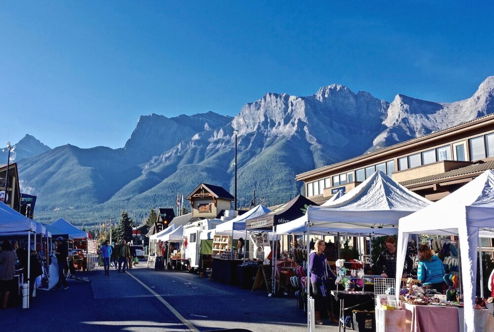 Market stalls in downtown Canmore, with a backdrop of rugged mountains