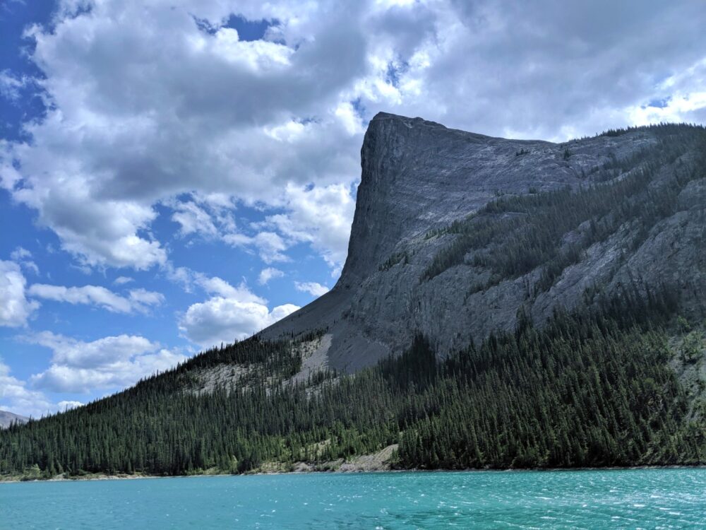 A striking mountain looms over a turquoise lake near Canmore