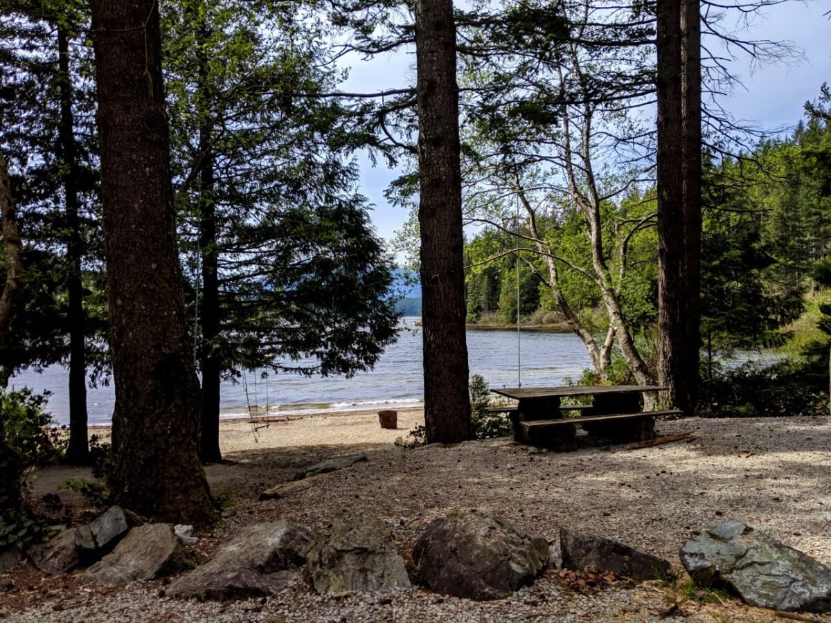 Lakeside campsite with picnic table and stone divider