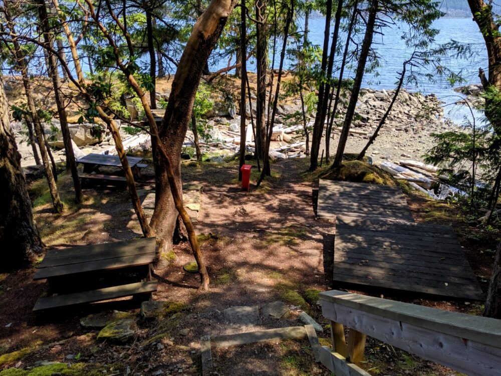 Looking down the stairs at Cabin Bay campground, with two picnic tables and two tent pads