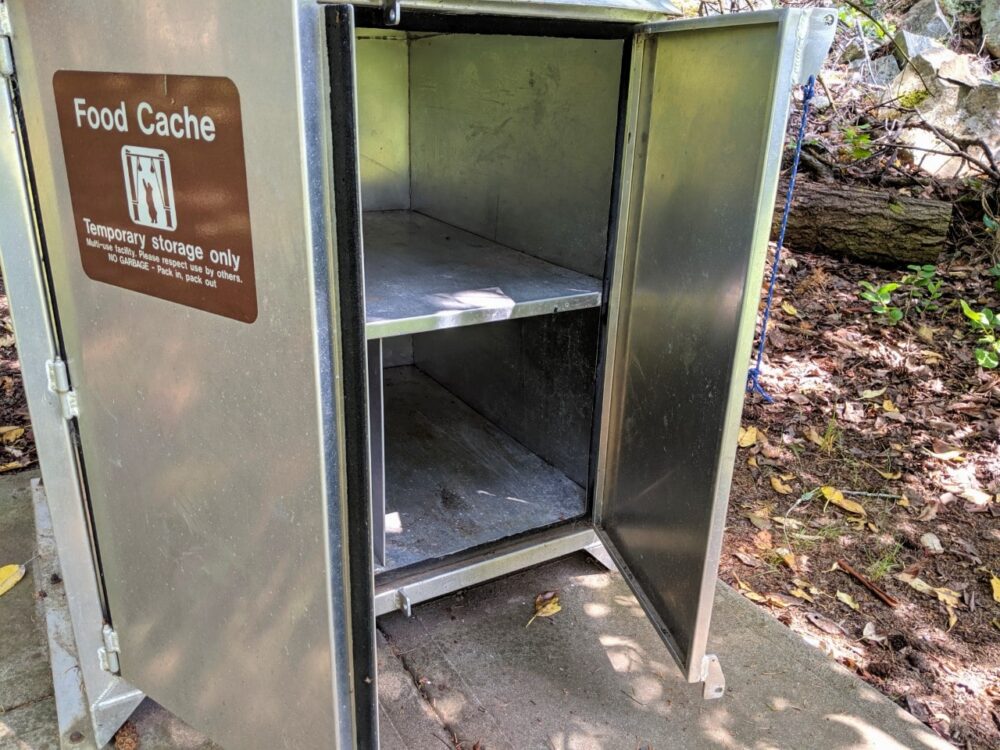 A metal food cache with doors wide open at Conover Cove