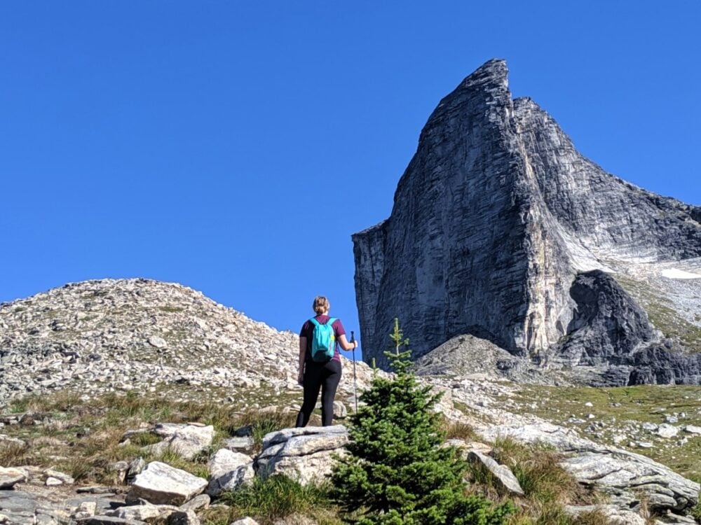 Gemma standing with hiking pole looking up towards the dramatic Gimli Peak in Valhalla Provincial Park