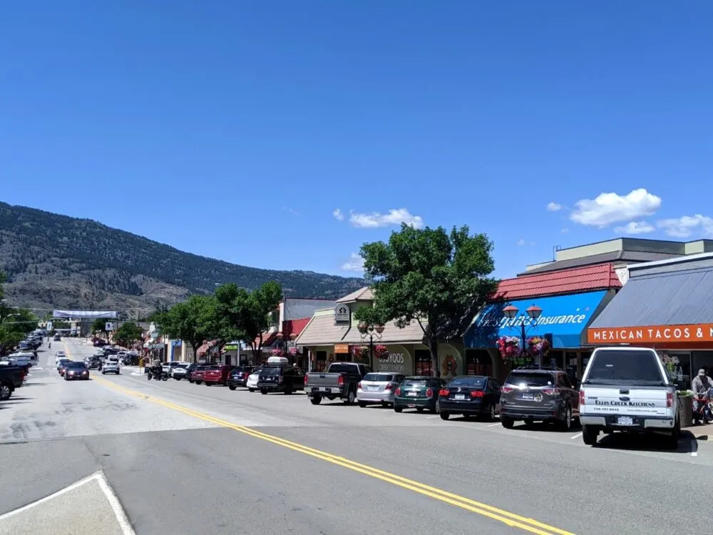 Downtown Osoyoos with parked cars on right hand side in front of stores