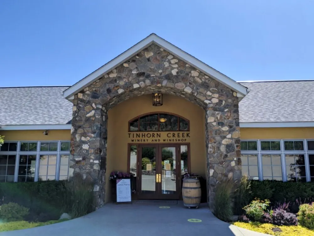 Tinhorn Creek Winery entrance with stone arch and wine barrel