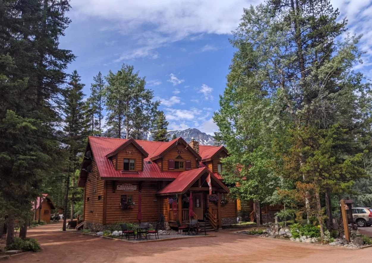 Two floor red roofed cabin style building at Baker Creek Mountain Resort, member of the Charming Inns of Alberta