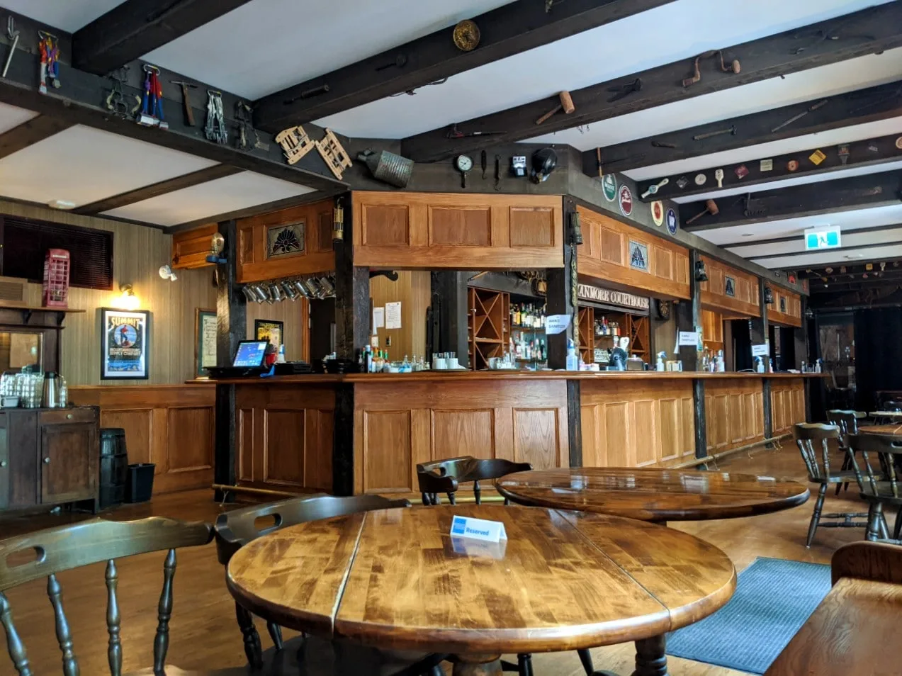 Inside the Miner's Lamp Pub, with English country pub style decor (wooden beams, wooden tables, paneled bar)