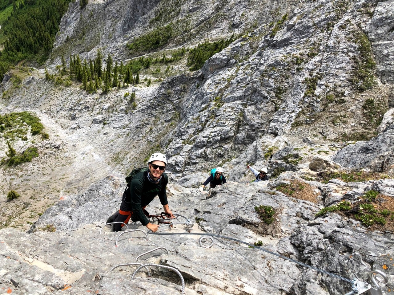 Overhead view of Gemma and JR climbing up Via Ferrata course on rockface