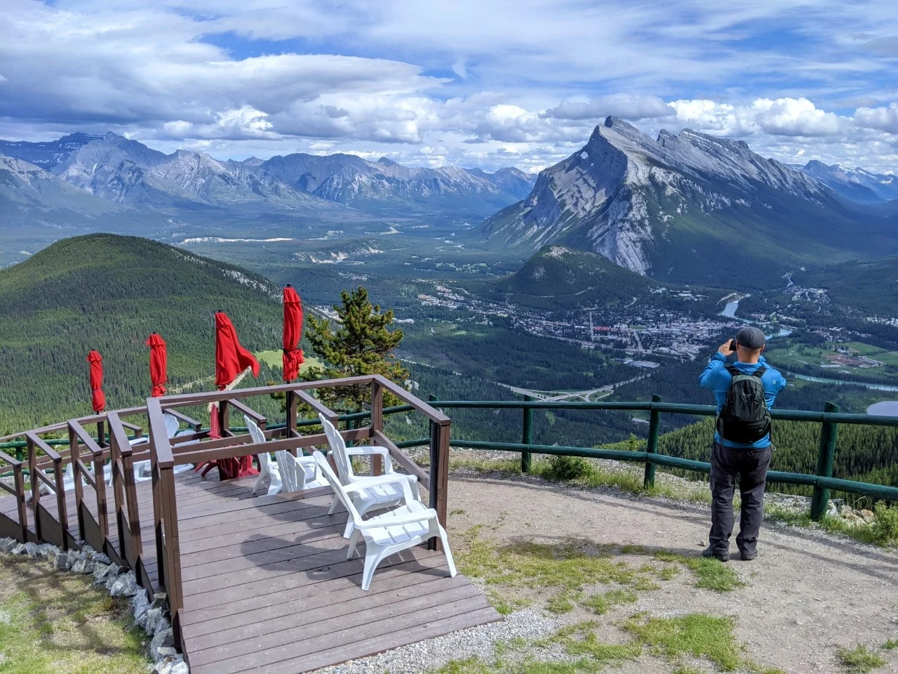 JR standing in front of mountain views at the top of Mt Norquay chairlift, taking a photo
