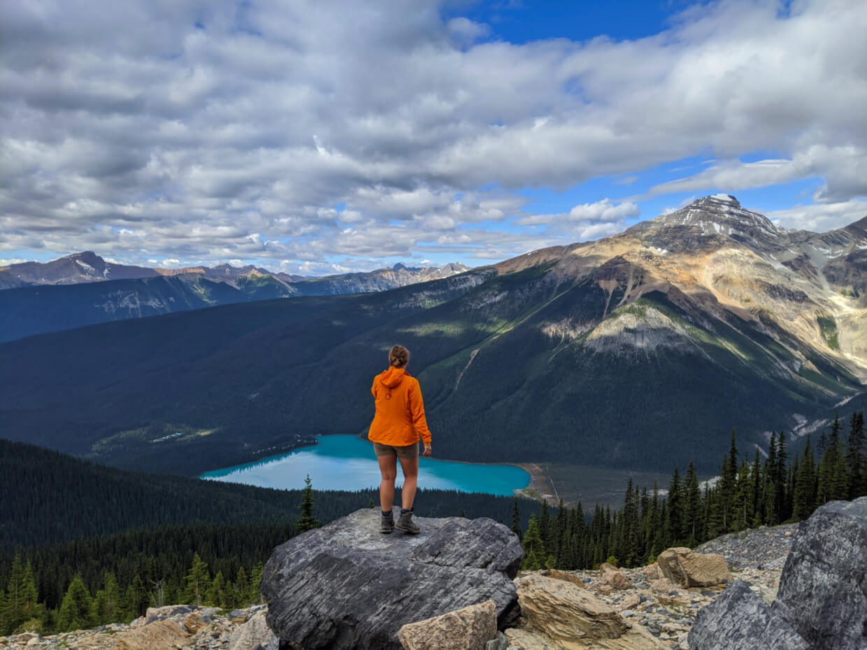 Gemma standing on a rock looking out to turquoise Emerald Lake, surrounded by mountains