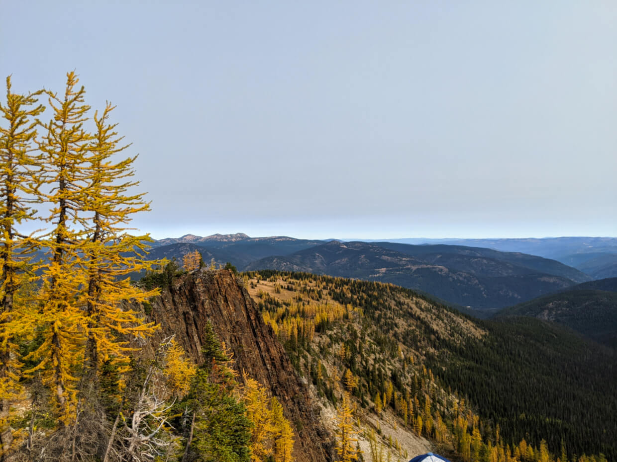Looking down the Frosty Mountain Trail from high point with golden larch trees below and mountain views