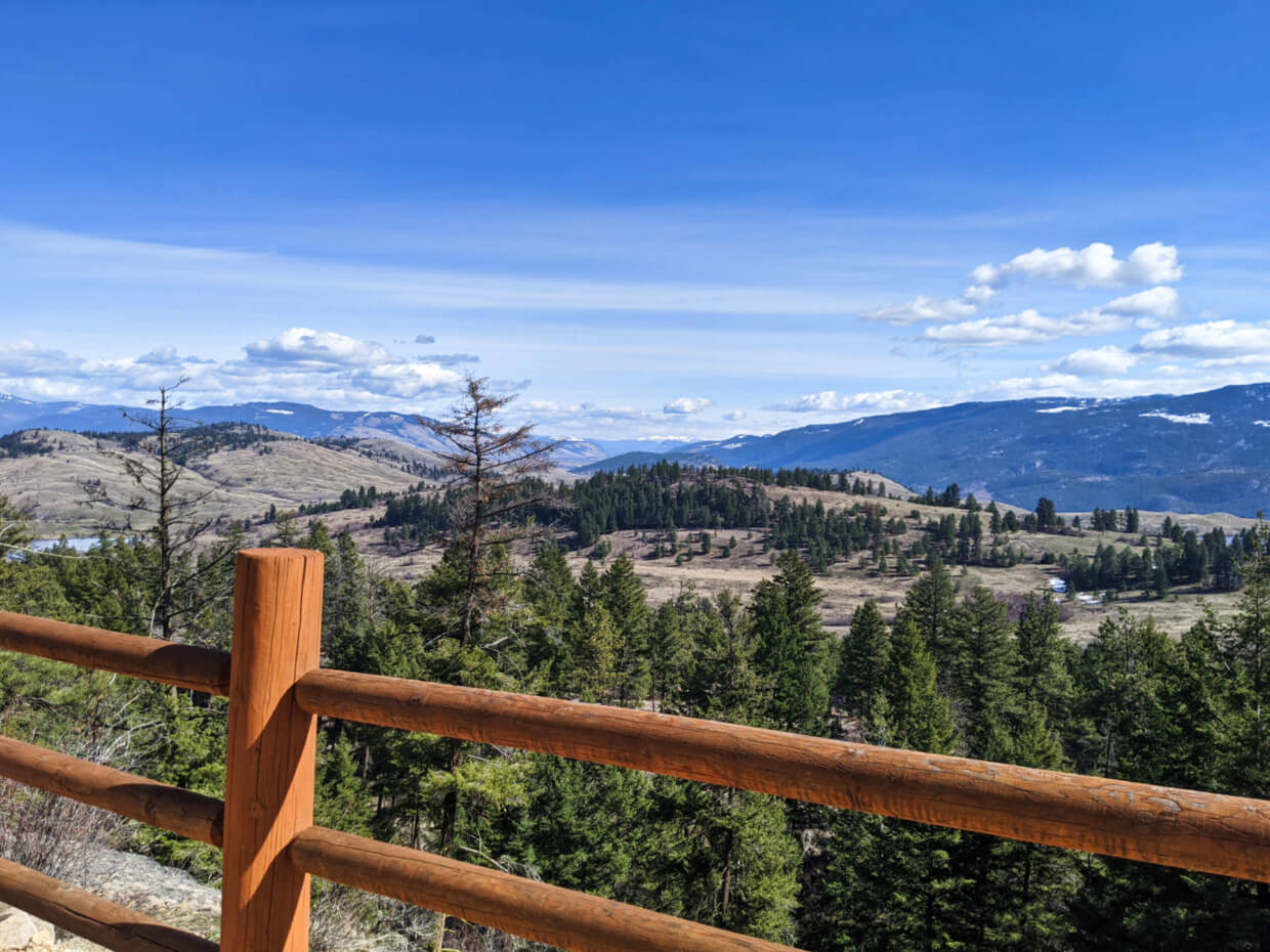 Looking over a wooden fence towards grasslands scenery at Predator Ridge resort