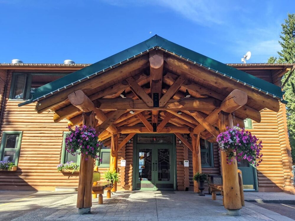 Front view of wooden entrance to Overlander lodge building, with flower baskets on each side 