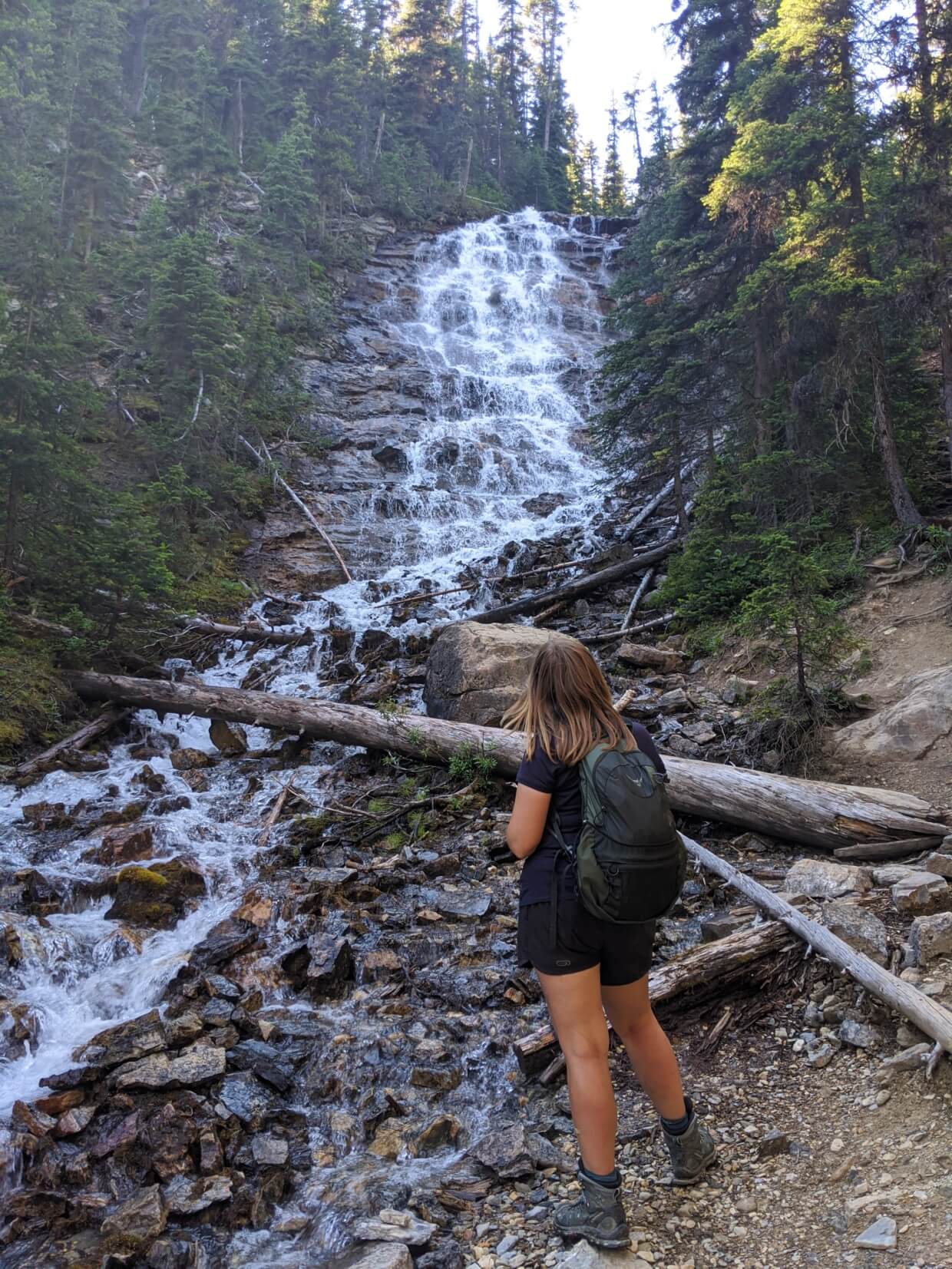 Back view of Gemma looking up at cascading waterfall on Iceline Trail, Yoho National Park