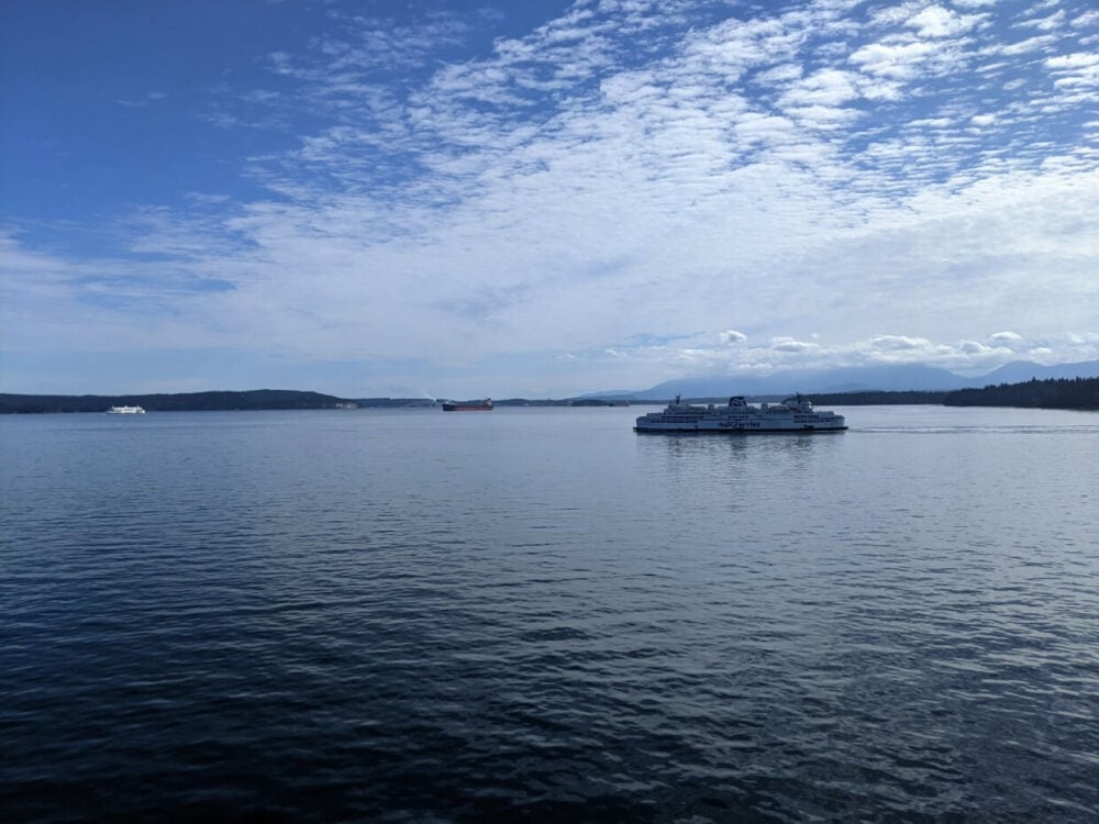 Looking out to Salish Sea with BC Ferries boats crossing in front of islands and mountin panoramas