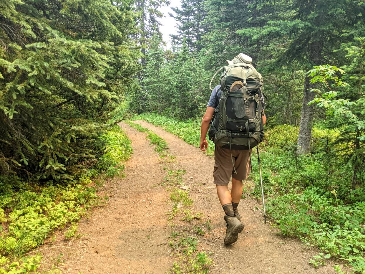 Back view of JR walking away from camera along two track dirt path