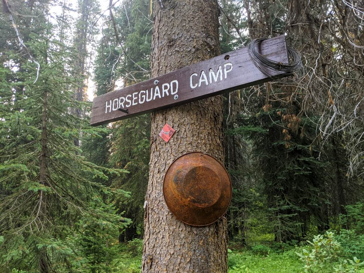 Close up of wooden Horseguard Camp sign on tree with metal gold pan underneath