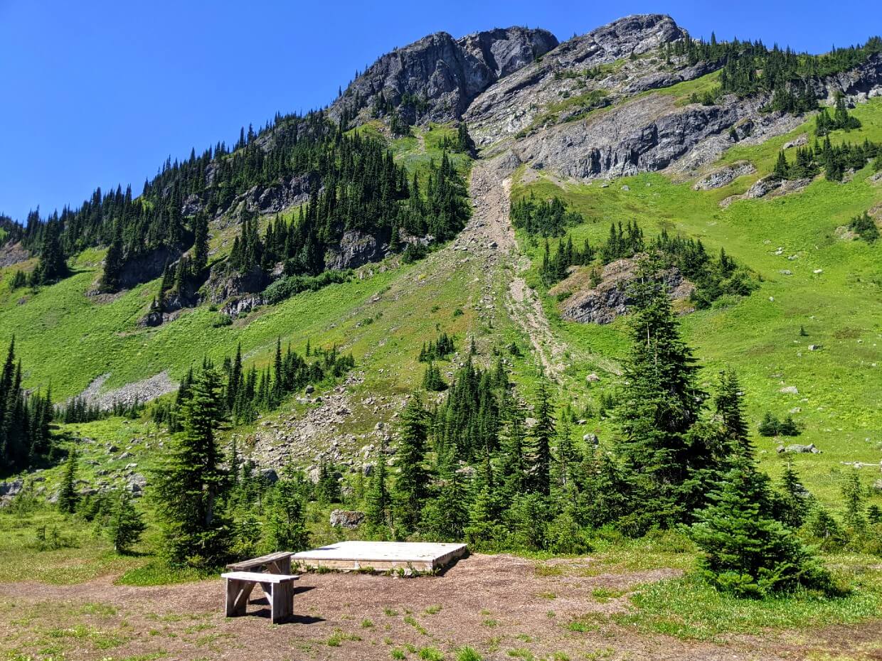 A wooden tent pad sits in Conglomerate Flats Camp in front of rocky Mt Davis