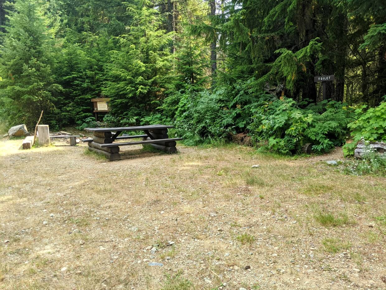 Side view of camping area at Sowaqua Creek with picnic table and fire pit in background