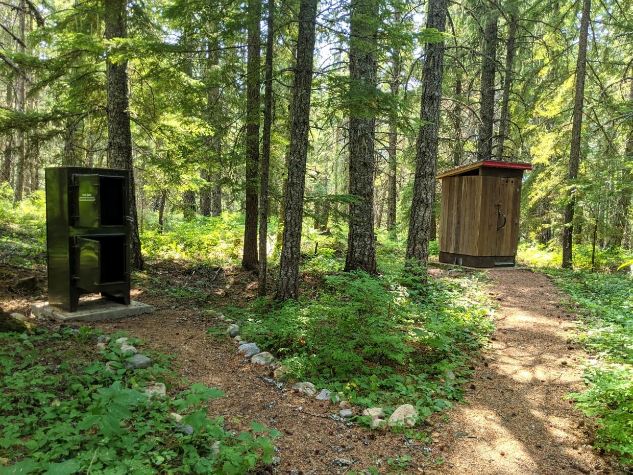 Forested area at Sowaqua Creek with outhouse and metal food cache