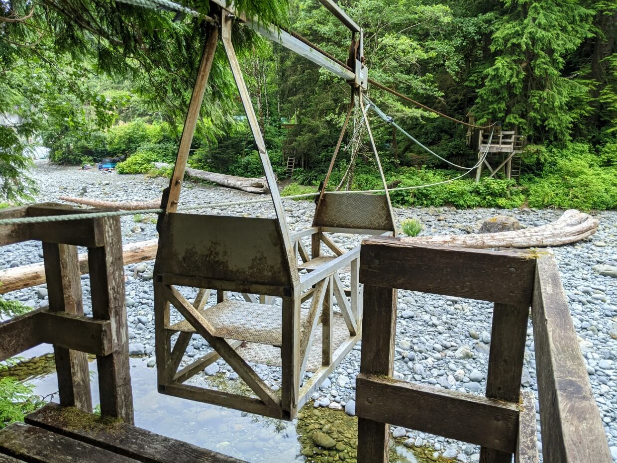 Elevated wooden platform and metal cable car above rocky Camper Creek on the West Coast Trail.