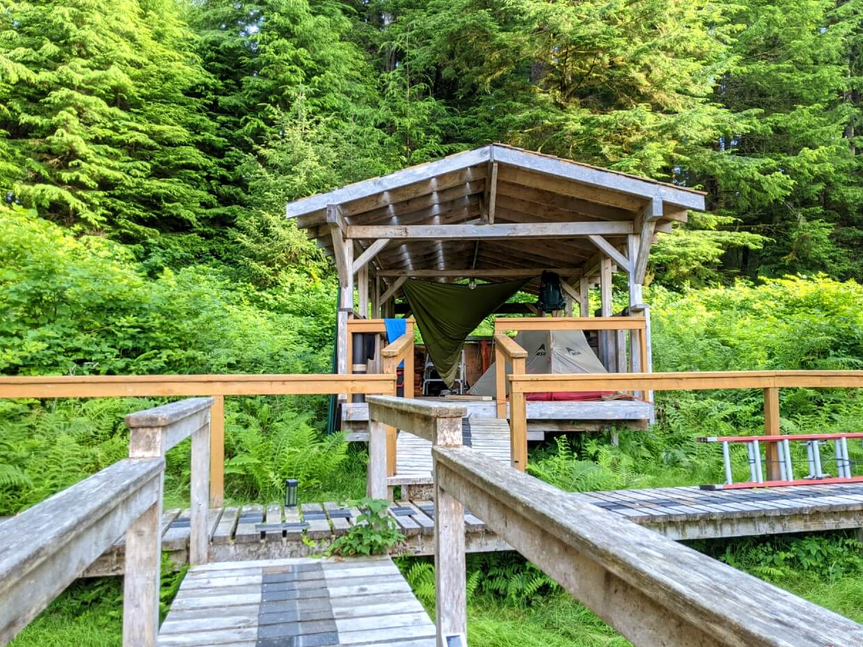 Overview of covered tent deck at Nitinaht Narrows from wooden boardwalk