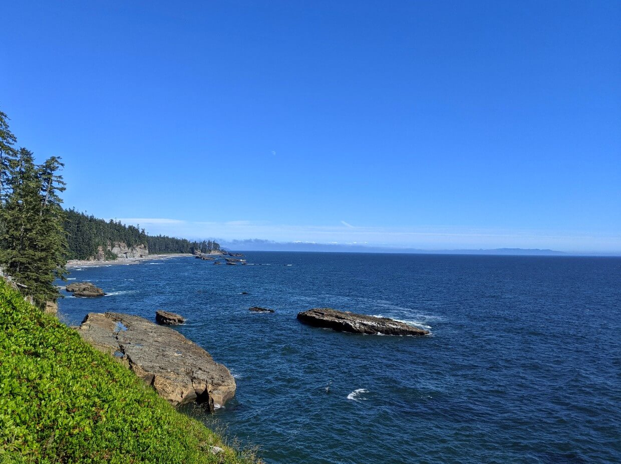 Elevated view looking over coastline with beautiful blue skies over calm ocean