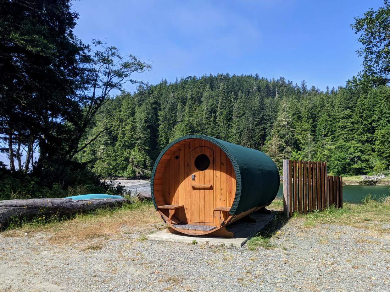 Colourful barrel shaped cabin in front of forest and river