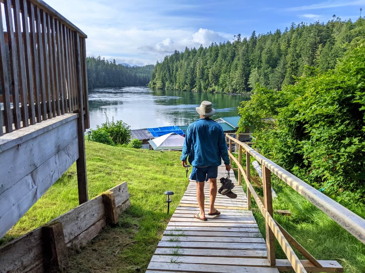 Back view of JR walking on boardwalk towards the Crab Shack, with Nitinaht Narrows in background