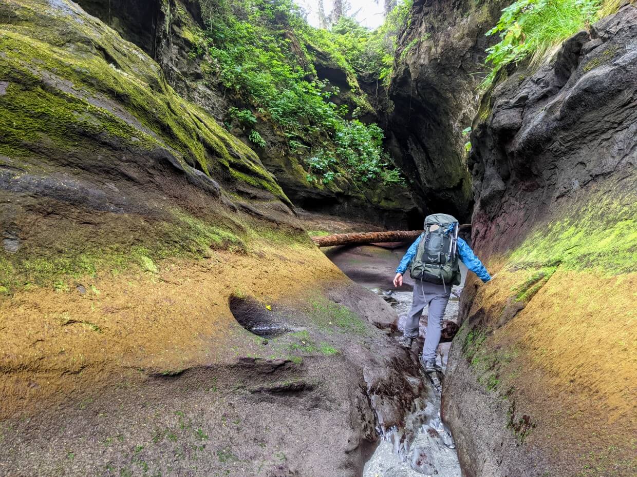 Back view of JR walking into colourful caves at Owen Point