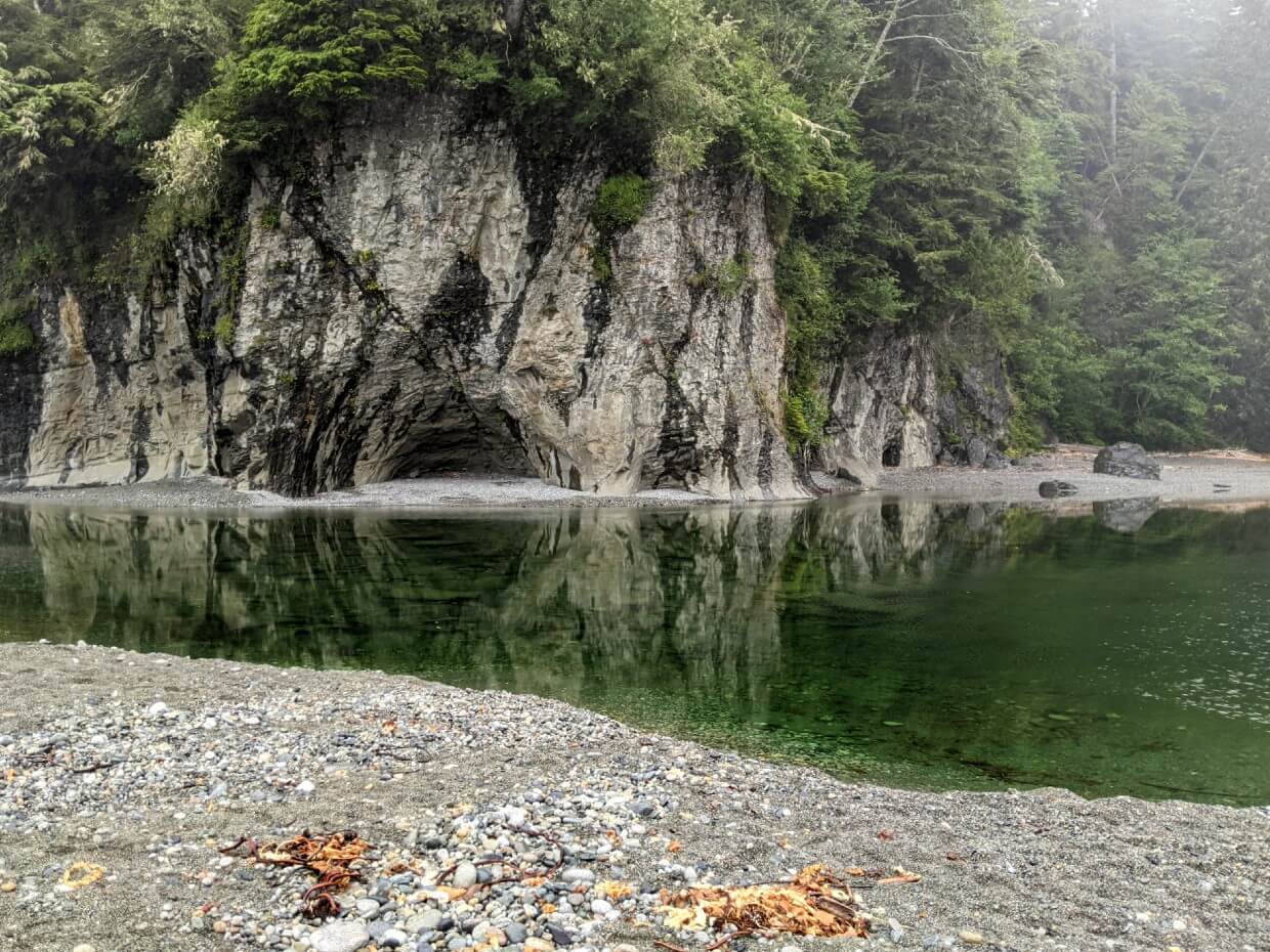 Looking across calm Walbran Creek towards caves 