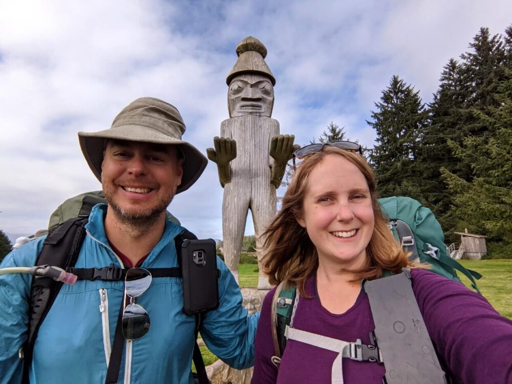 JR and Gemma selfie in front of carved Welcome/Watchman figure in Yuquot